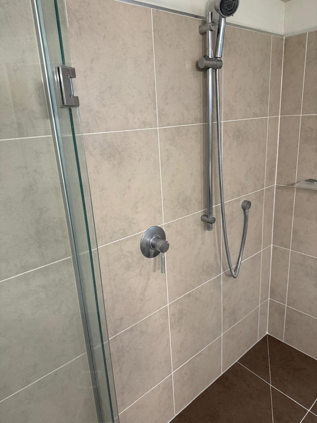 After restoration: clean shower wall tiles with bright grout lines